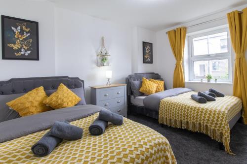 a bedroom with two beds with blue and yellow sheets at Open Mind Property - Cosy Apartment with 3 Beds in Portsmouth