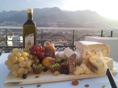 a table with a plate of cheese and a bottle of wine at Al Mandari Hôtel Tétouan in Tetouan