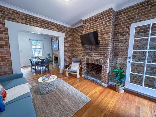 a living room with a brick wall with a fireplace at Serenity home in the heart of city in Sydney