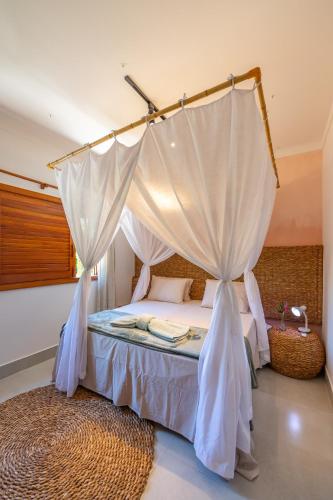 a bedroom with a bed with a canopy at Bahia Soul - Morada Garú - Taipu de Fora - Península de Maraú in Taipu
