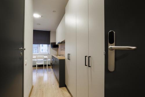 a small kitchen with a white door and a table at Restart in Kaunas