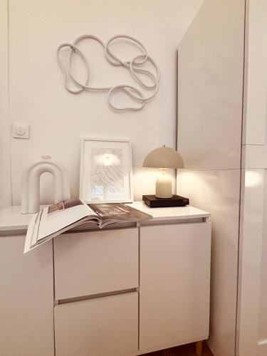 une table avec une lampe et un livre sur celle-ci dans l'établissement Paris Moments, Your Moments, à Paris