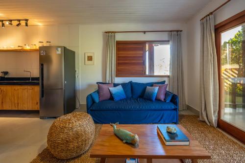 a living room with a blue couch and a table at Bahia Soul - Morada Garú - Taipu de Fora - Península de Maraú in Taipu