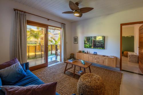 a living room with a blue couch and a table at Bahia Soul - Morada Garú - Taipu de Fora - Península de Maraú in Taipu