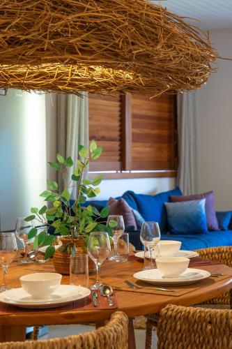 a dining room table with plates and wine glasses at Bahia Soul - Morada Garú - Taipu de Fora - Península de Maraú in Taipu