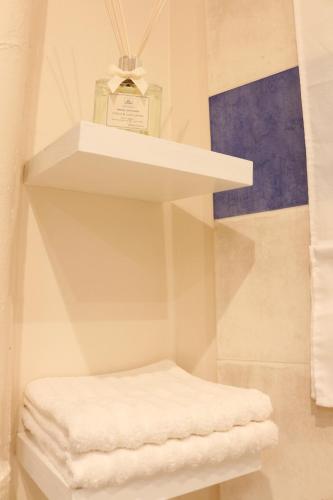 - une étagère blanche avec une bouteille de parfum dans l'établissement Paris Moments, Your Moments, à Paris