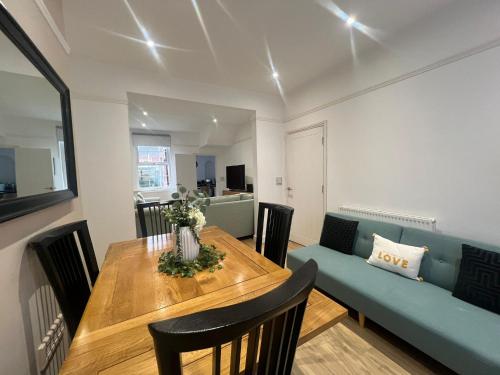 a dining room with a table and a blue couch at Charming 2-Bedroom home in Leamington Spa in Leamington Spa