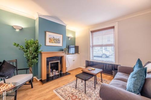 a living room with a couch and a fireplace at 2BR Character Home Minutes from Windsor, Private Garden - By Tempstay in Windsor