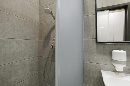 a bathroom with a shower with a sink and a mirror at Restart in Kaunas