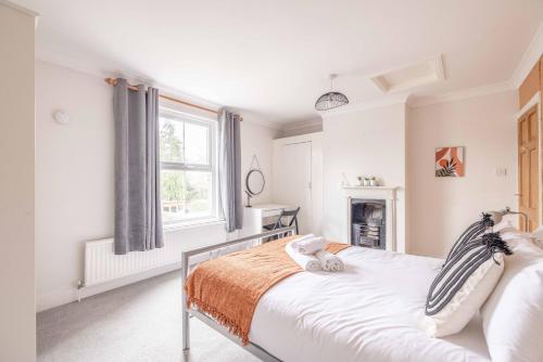 a white bedroom with a bed and a window at 2BR Character Home Minutes from Windsor, Private Garden - By Tempstay in Windsor