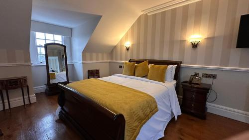 a bedroom with a large bed with a yellow blanket at Sweeney's Hotel 2020 Limited in Dungloe