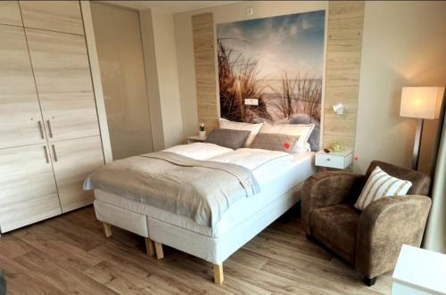 a bedroom with a large bed and a chair at Gemütliches Apartment,Bad,Küche, Wifi am Rande Hannovers in Wedemark
