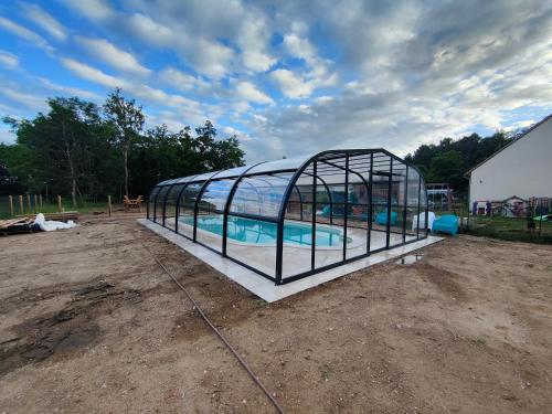 une serre avec une piscine. dans l'établissement Un amour passionnel,love room, balnéo privatisée15 min du zoo,piscine couverte et chauffée d'avril à octobre à partager avec d'autres logements et elle est privatisée de 20h à 22h, à Meusnes