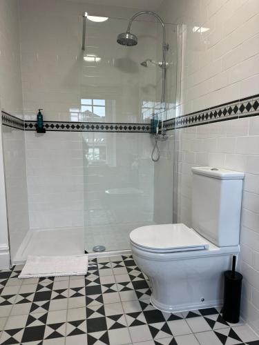 a white bathroom with a shower and a toilet at Sweeney's Hotel 2020 Limited in Dungloe