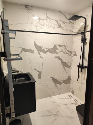 a bathroom with a sink and a marble wall at Luxury Apartment 5 Mins from Slopes Parking in Bansko