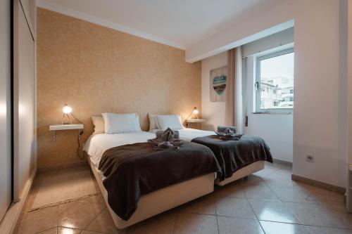 une chambre avec un grand lit avec une fenêtre dans l'établissement Apartamentos Julieta, à Albufeira