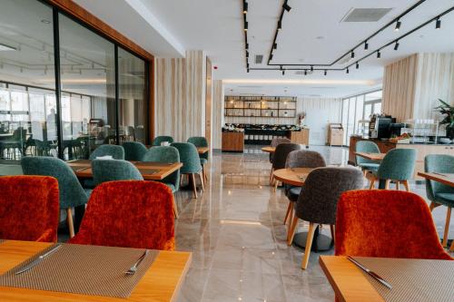 a dining room with tables and chairs and windows at The Emporia Hotel in Pamukkale