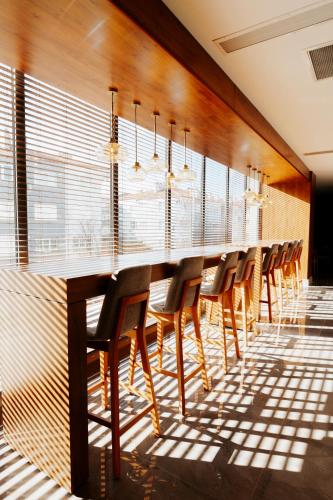 a long bar with wooden chairs and windows at The Emporia Hotel in Pamukkale