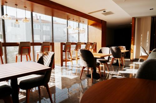 a restaurant with wooden tables and chairs and windows at The Emporia Hotel in Pamukkale