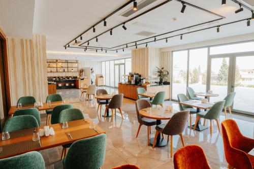a restaurant with tables and chairs and windows at The Emporia Hotel in Pamukkale
