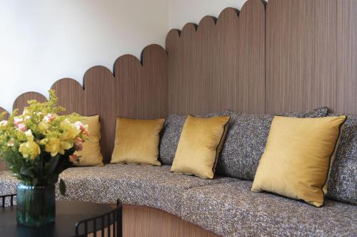 a couch with pillows and a vase of flowers on a table at 1.75 Paris La Source in Paris
