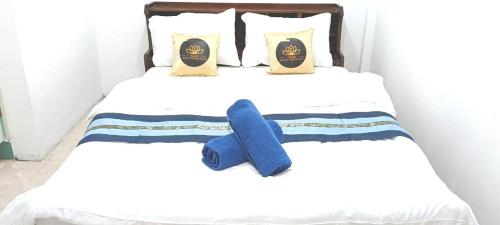 a bed with a blue teddy bear on it at Marine Guest House Encore in Pattaya South