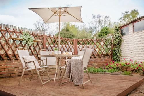 a patio with a table and chairs and an umbrella at Serene Boho Retreat: White Oak Charm House 10ppl in Sheffield