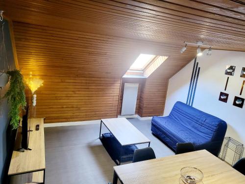 a living room with a blue couch and a table at éclat de saphyr in Murat