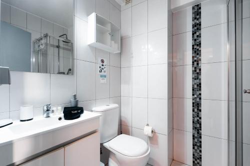 une salle de bain blanche avec toilettes et lavabo dans l'établissement Apartamentos Julieta, à Albufeira