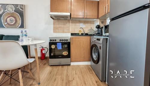 a kitchen with a stove and a dishwasher at Rare Holiday Homes - Lake View - The Lago Vista Tower A - Dubai Production City - R1503 in Dubai