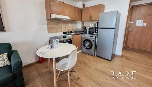 a small kitchen with a table and a refrigerator at Rare Holiday Homes - Lake View - The Lago Vista Tower A - Dubai Production City - R1503 in Dubai