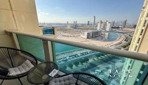 a balcony with chairs and a view of a city at Rare Holiday Homes - Lake View - The Lago Vista Tower A - Dubai Production City - R1503 in Dubai