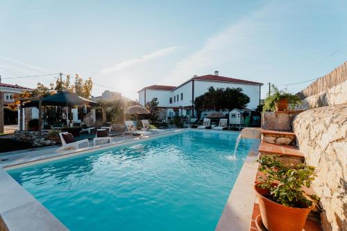 a swimming pool with blue water in a yard at Casa da Cerca-Suíte Aconchegante com Piscina in Runa