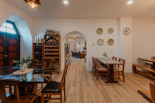 a dining room with tables and chairs and a room with wine bottles at Casa da Cerca-Suíte Aconchegante com Piscina in Runa