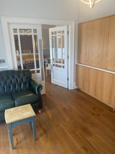 a living room with a green couch and a table at Sweeney's Hotel 2020 Limited in Dungloe