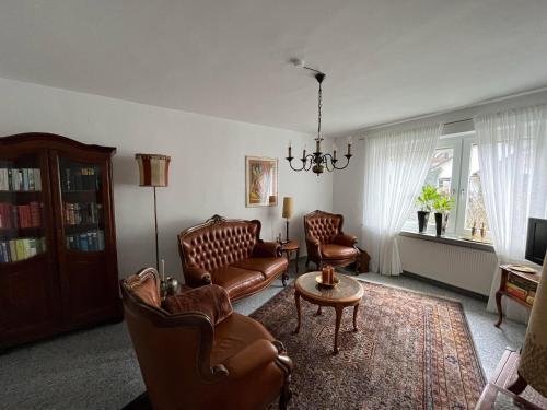 a living room with leather chairs and a table at Haus Arthur Klingels in Bad Bertrich