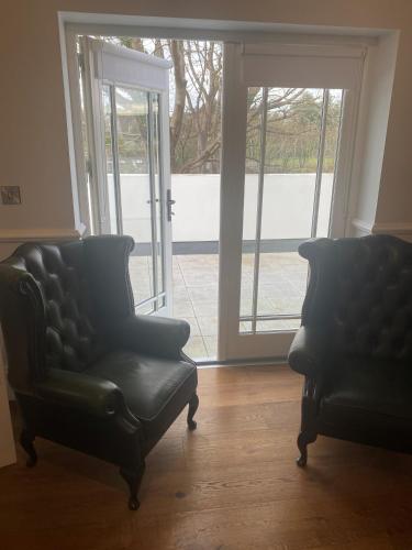 two chairs sitting in a living room with a window at Sweeney's Hotel 2020 Limited in Dungloe