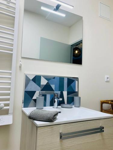 une salle de bain avec un lavabo et un miroir dans l'établissement Le Marechal - T2 Hypercentre La Rochelle - Wifi, à La Rochelle