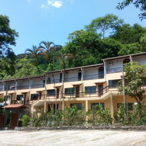 an apartment building with trees in the background at Ap. Duplex Praia grande Ubatuba in Ubatuba