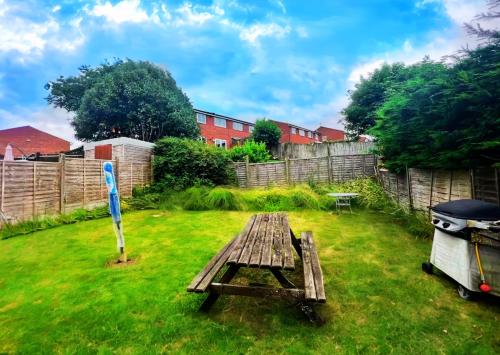 a picnic table in a yard with a fence at Badger Haven, Apartment 2 in Brackley