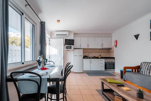 a kitchen and living room with a table and chairs at Apartamentos Julieta in Albufeira