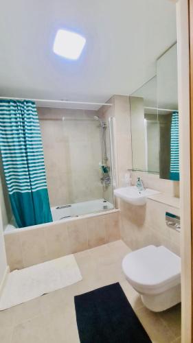 a bathroom with a toilet and a sink and a tub at Luxury 1 bed flat at WembleyPark in London
