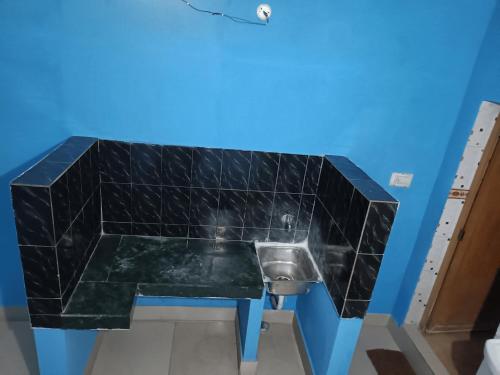 a bathroom with a black marble counter with a urinal at Chandrakanta Guest House in Puri