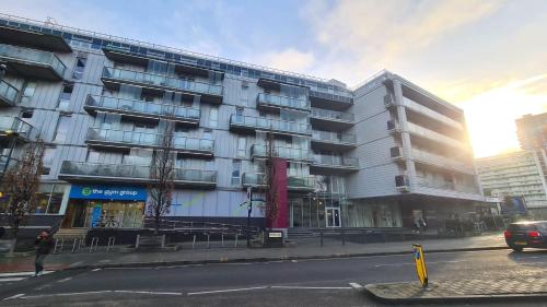 a building on a city street with a car parked in front at Luxury 1 bed flat at WembleyPark in London