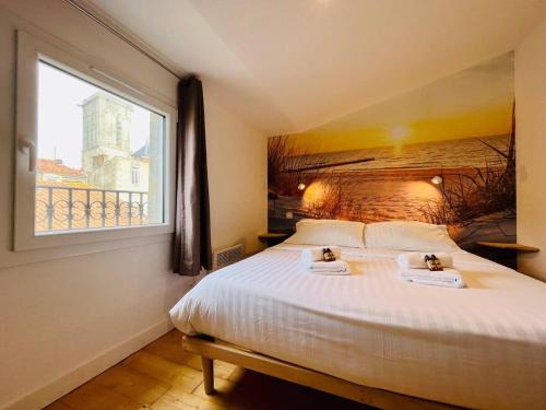 une chambre avec un grand lit avec une fenêtre dans l'établissement Appartement Vue Port - Joli T2, à La Rochelle