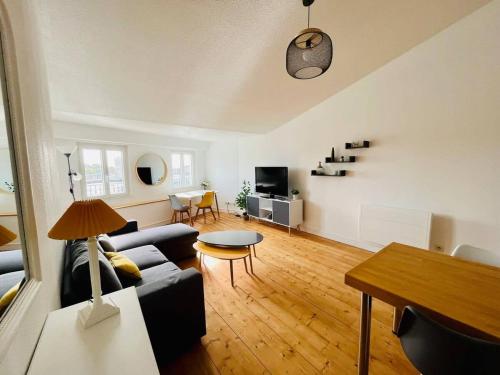 un salon avec un canapé et une table dans l'établissement Appartement Vue Port - Joli T2, à La Rochelle