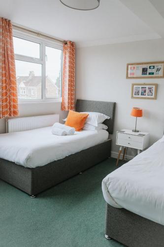 two beds in a small room with a window at Hayward's at the Grasmere in Keynsham
