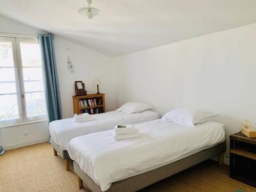 - 2 lits dans une chambre avec des draps blancs et une fenêtre dans l'établissement Le Capricorne Plein Centre Ville La Rochelle Wifi, à La Rochelle