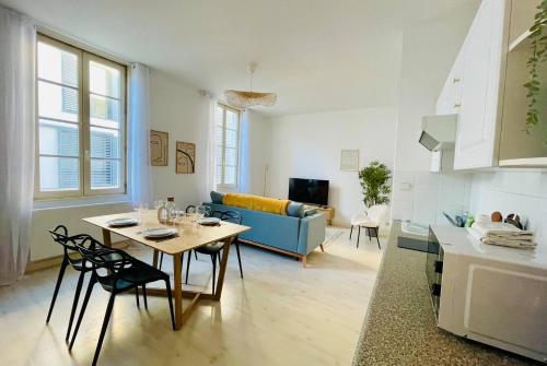 un salon avec une table et un canapé bleu dans l'établissement Le Saint Nicolas - Hypercentre La Rochelle - Wifi, à La Rochelle