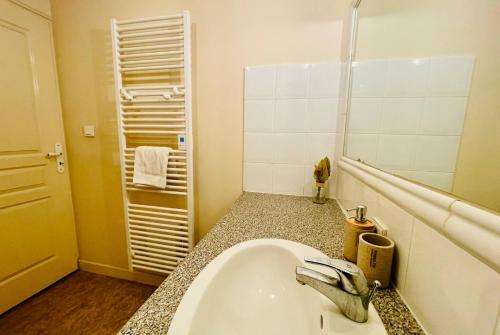 une salle de bain avec un lavabo et un miroir dans l'établissement Le Saint Nicolas - Hypercentre La Rochelle - Wifi, à La Rochelle